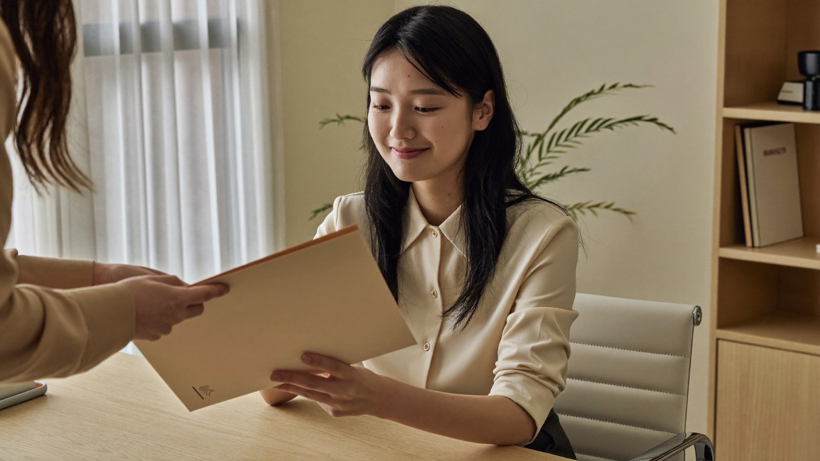 พนักงานใหม่รับแฟ้มเอกสารกองทุนสำรองเลี้ยงชีพจาก HR ที่โต๊ะทำงาน